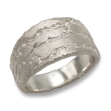 A chunky silver ring etched with the words on and on on a white background. 