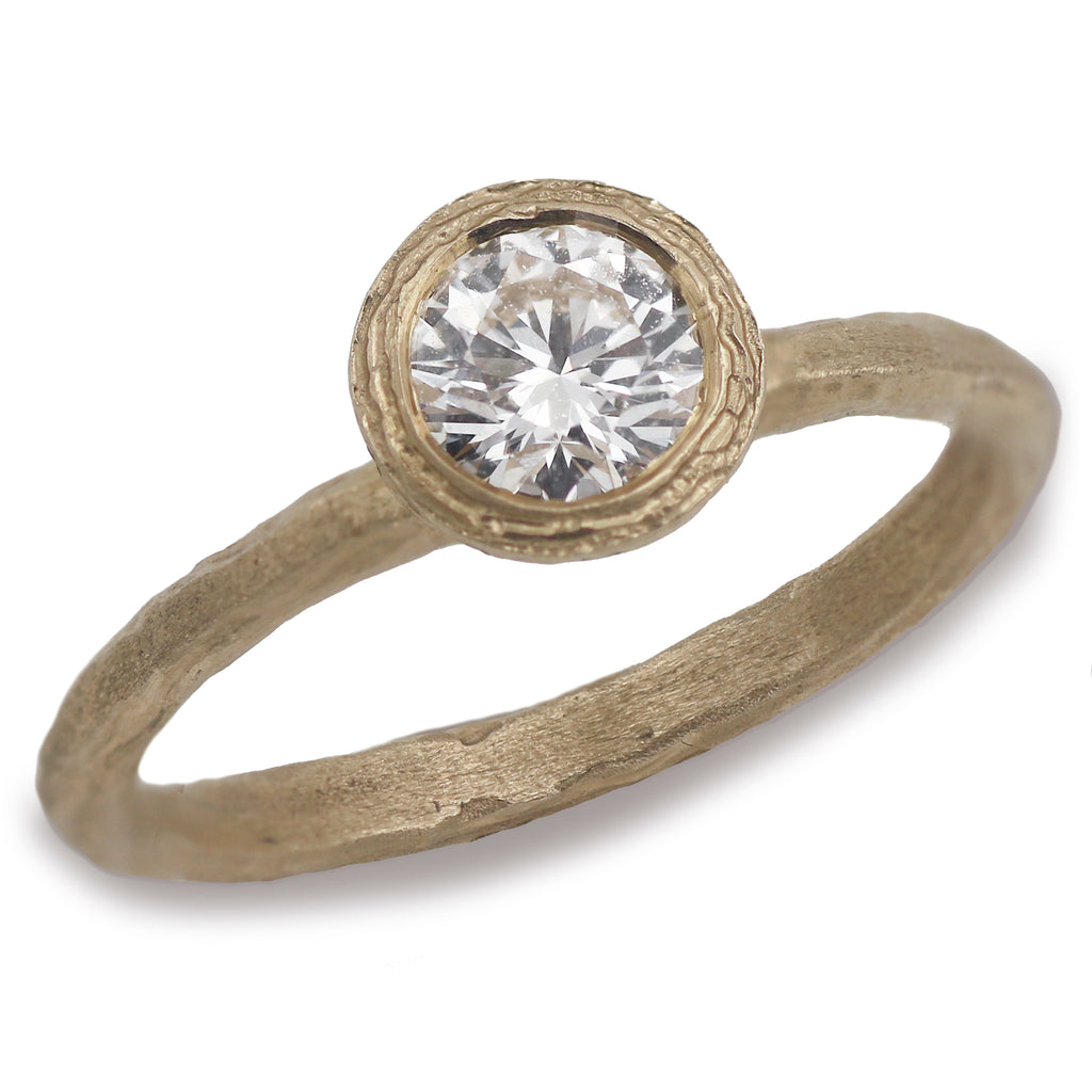 A lab grown solitaire diamond ring made from yellow gold on a white background. 