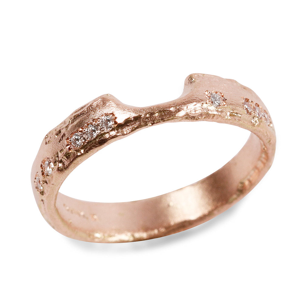 Rose gold fitted wedding band with diamonds on white background 