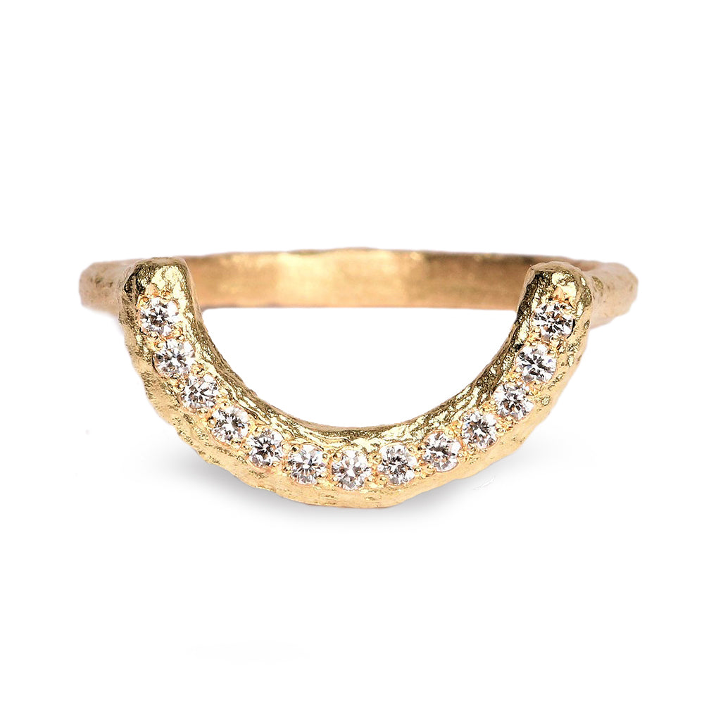 Shaped textured fitted gold wedding ring with diamonds on white background 