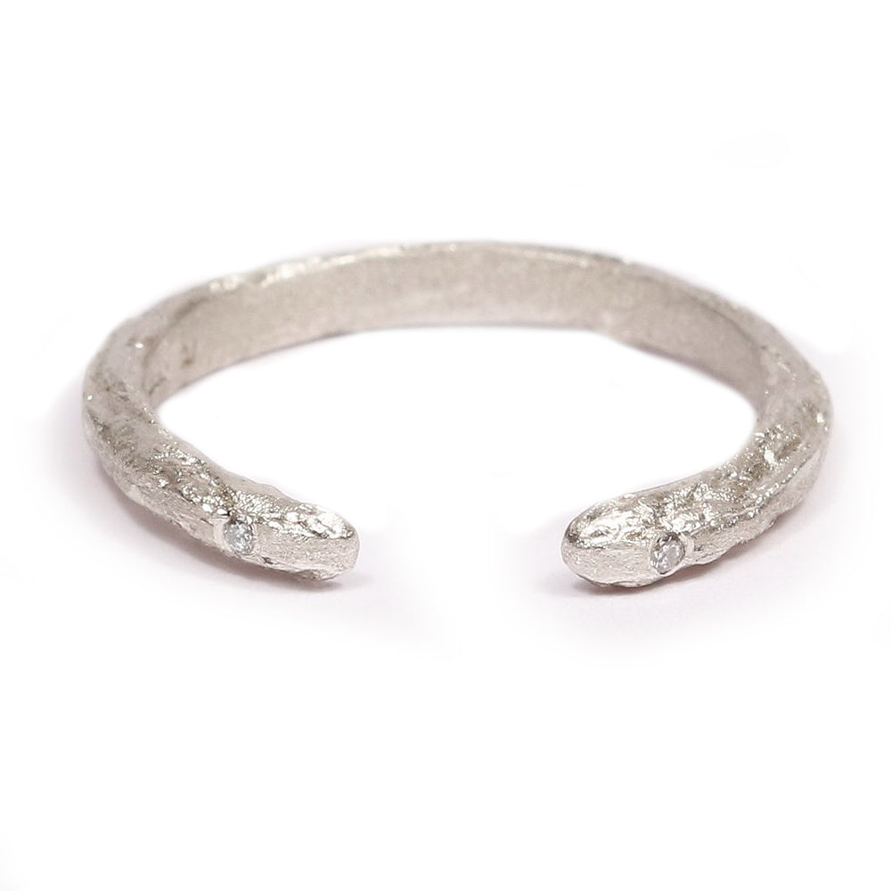 Textured white gold open wedding ring with diamonds on a white background 